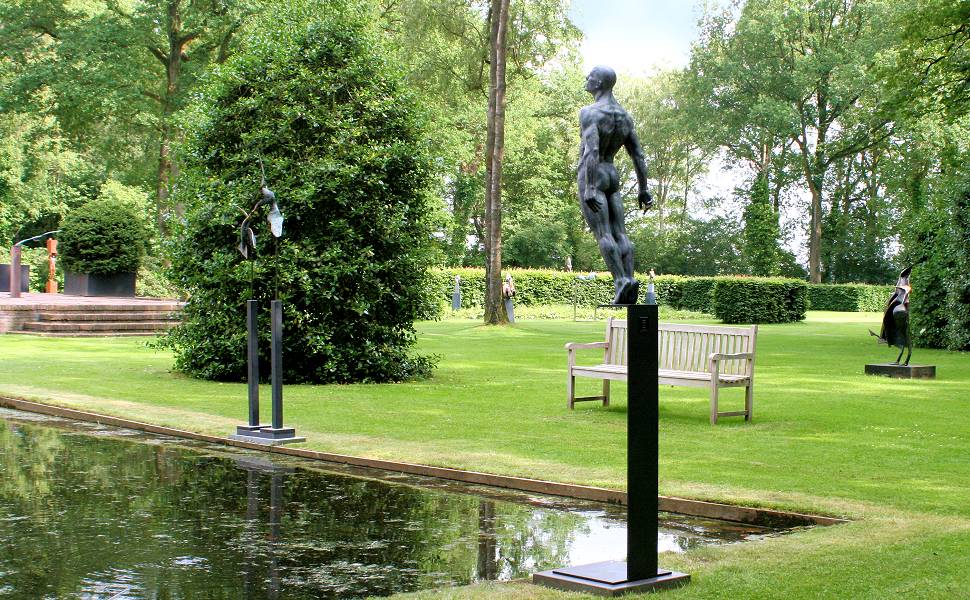 Bezoekers kijken naar een grote bronzen gorilla in de beeldentuin van galerie Wildevuur